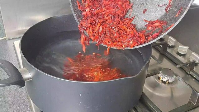 Ukrainian national dish red borsch on gas stove in saucepan