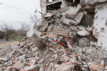 IZYUM, UKRAINE - April 8, 2023: Photos of the civilians, commemorative candles and flowers at the death scene of the residents of the destroyed by russian army house.