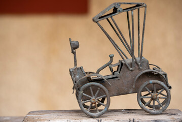 Antique rickshaw toy on wooden table with blur background. Old Car