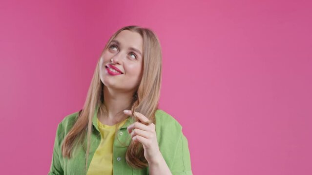 Playful woman smiling, flirting to camera on pink background. Lady wants to meet
