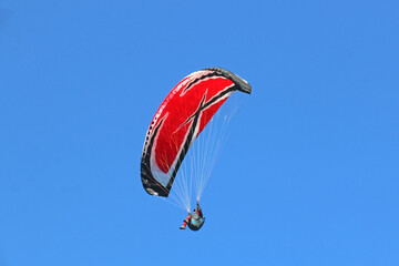 Paraglider flying in a blue sky	