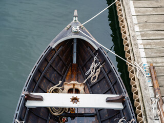 Looking down into a custom made rowboat made of wood on a dock in Rockland Maine