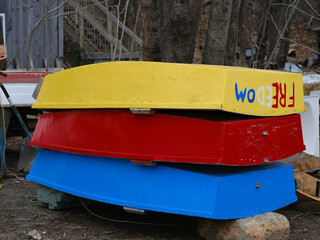 Fototapeta na wymiar Colorful small skiffs in yellow, red and blue sit on a dock in Rockland Maine
