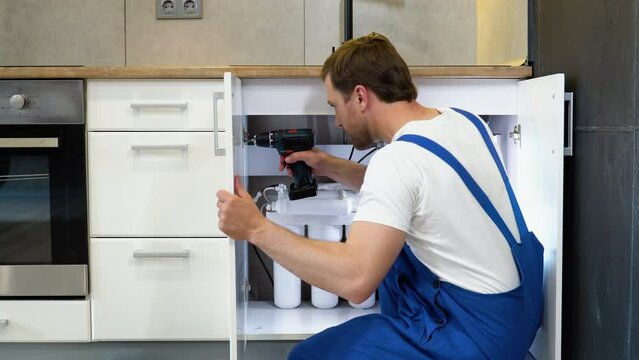 Young man assembling kitchen furniture