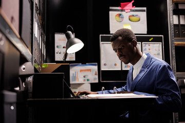 Investigator working at criminal case, reading files with confidential information in arhive room....