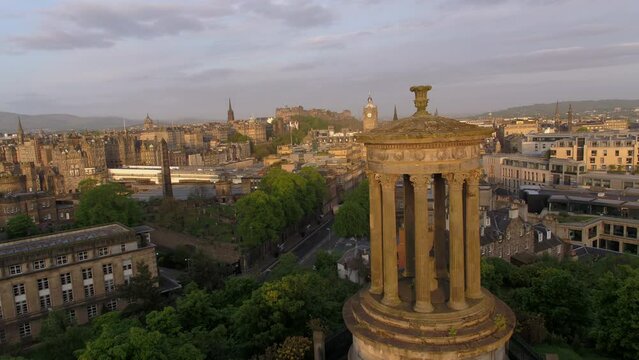 Spectacular Edinburgh city sunrise with monument in the foreground on Calton Hill drone aerial