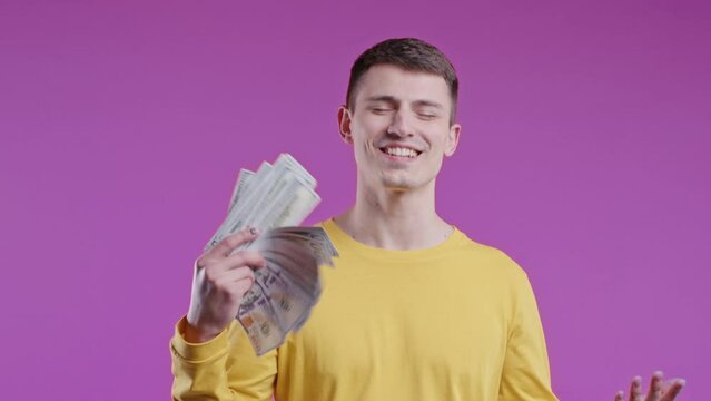 Rich excited man with cash money - USD currency dollars banknotes on pink