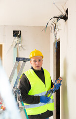 Portrait of satisfiedpositive friendly construction worker standing at indoors building site