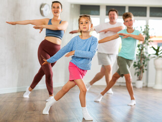 Naklejka na ściany i meble Family with two children engaged in active dancing in fitness studio