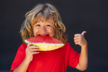 Funny child eat watermelon. Kid is picking watermelon on gray background.