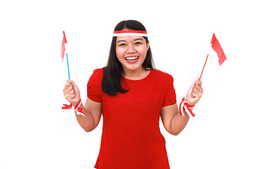Fototapeta premium Cheerful young indonesian girl standing while holding red white flag. Isolated on white