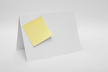 Folded paper with notes attached on white background