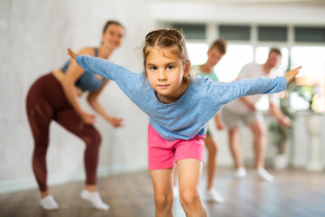Parents with daughter and son practice dance moves in fitness class