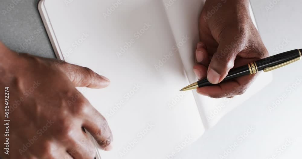 Poster close up of hand writing with pen on book with copy space on white background in slow motion