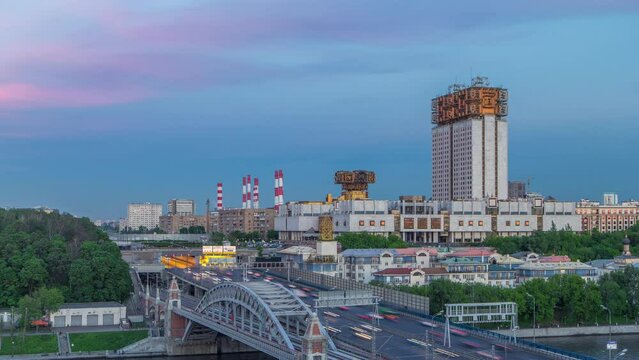 Evening view at the Russian Academy of Sciences day to night transition timelapse and Novoandreevsky Bridge over the Moscow River. Aerial view from rooftop after sunset