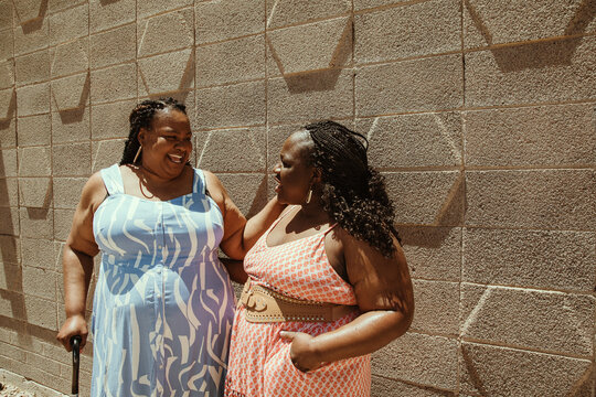 2 plus size African American women look at each other