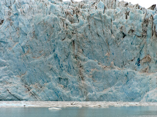 Fototapeta na wymiar The massive face of the Surprise Glacier on Prince William Sound on a foggy and misty day seen from the water