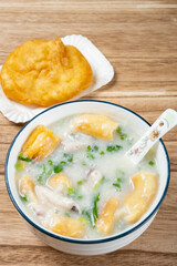 angle view fish porridge with deep-fried Chinese donuts at vertical composition
