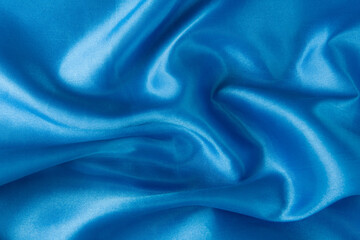 Abstract blue silk fabric texture background. Creases of satin	

