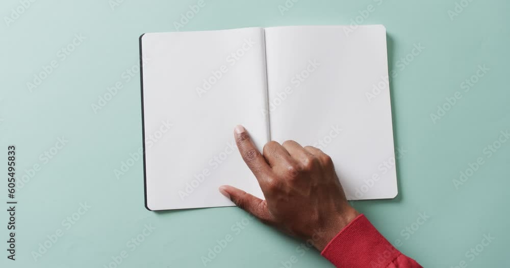 Poster close up of hand writing with pen on book with copy space on white background in slow motion
