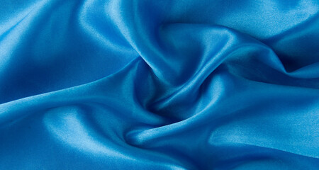 Fototapeta premium Abstract blue silk fabric texture background. Creases of satin 