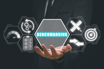 Benchmarking concept, Businessman hand holding benchmarking icon on virtual screen.