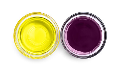 Glass bowls with yellow and purple food coloring on white background, top view