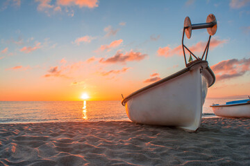 Small wooden boat on pier sandy beach. Mediterranean sea. old boats on the sandy shore. small wooden fishing boats on the sand near the sea. Boat on the beach at sunset time in Algeria Africa. © Mediterranean sea