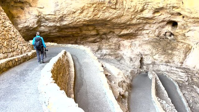 Man With Camera Descends Paved Swithbacks into Carlsbad Caverns