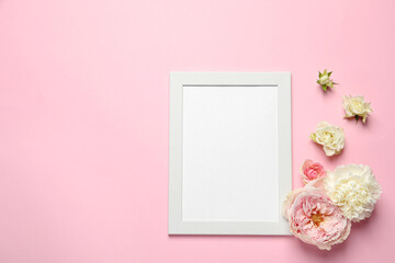 Fototapeta na wymiar Empty photo frame and beautiful flowers on pink background, flat lay. Space for design