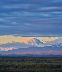 Vertical image of the Snow and cloud covered Mount Logan Peak of the Wrangell-St Elias mountain range in Alaska at 10:30PM in the evening