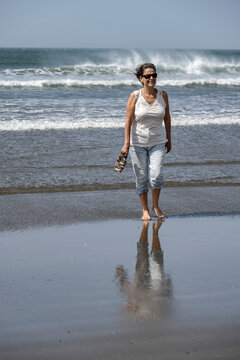 mujer, tercera edad, jubilaci&oacute;n, playa, olas rompientes, espuma marina, oc&eacute;ano atl&aacute;ntico, una mujer sola, mojada, descalzo, agua, ola, espuma, al aire libre, sin mangas, viento, mar, acu&aacute;tico, oce&aacute;no,