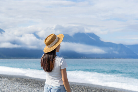 Woman with straw hat in the beach with clear blue sky