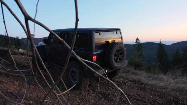 Jeep Wrangler driving through difficult gravel road in the mountains. Washington State, USA - circa 2022.