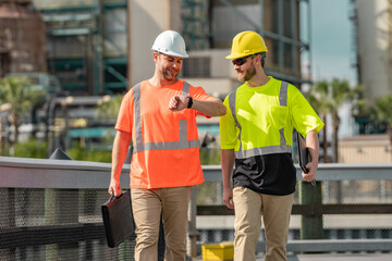 Industrial workers outdoors. Engineers in safety uniform and helmet on factory outdoor. Industrial engineers with factory worker. Factory industrial engineers walking outdoor.