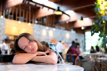 teenage girl fell asleep on table in the restaurant waiting for her friend tired oh hard I study relationships with friends
