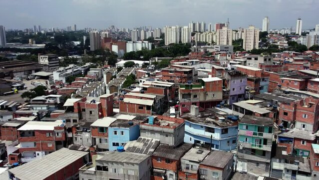 Aerial parallax view of metropolitan slum homes in South America, on a sunny day
