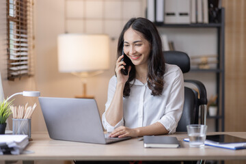 Fototapeta na wymiar Happy caucasian young Asian woman using smart phone cellphone for calls, social media, mobile application online in office money financial planning Business And Education Concept.