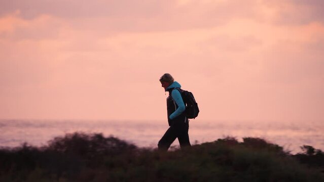 Solo female hiker walking desert ocean coastal path 