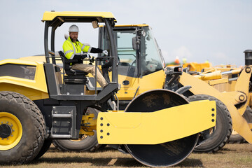 machinery in a industry with hispanic construction worker. construction worker used heavy machinery. construction industry with machinery worker. construction machinery worker outdoor