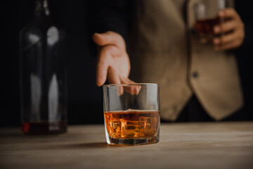 Bartender serving whiskey on wooden bar ,Close-up shot of whiskey glass