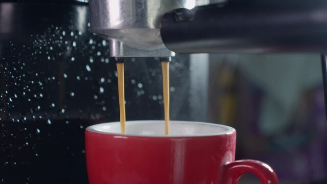 Pouring coffee stream from machine in cup. Home making hot Espresso. Using filter holder. Flowing fresh ground coffee. Drinking roasted black coffee in the morning. Footage B Roll shot of coffee pour.