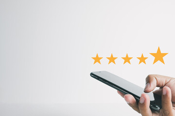 Customer Review, satisfaction,feedback concept.,Hand using smartphone with five star icon give...