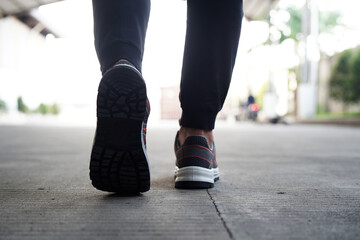 Photo of a man doing his morning run and wearing sports shoes and sweatpants        