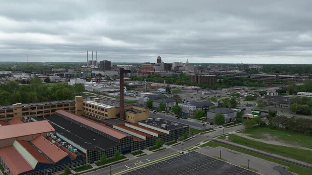Drone timelapse video moving left to right wide shot of downtown Lansing, Michigan skyline and Michigan state capitol building with Prudden building in foreground.