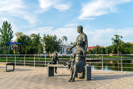 Astrakhan, Russia - September 23, 2022: Sculptural composition "Family". The composition is based on a married couple with children, who comfortably settled down on a bench near Swan Lake