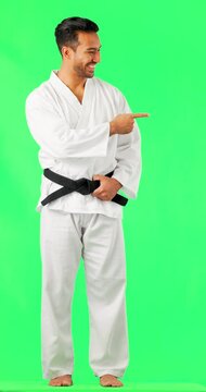 Face, karate and man pointing to green screen studio for fitness, sports and exercise on mockup background. Martial arts, trainer and portrait of asian male show training, workout or dojo advertising
