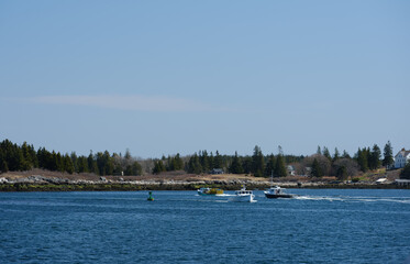 Obraz premium Lobster boats coming into and out of the North Haven harbor on Vinalhaven Island in Maine