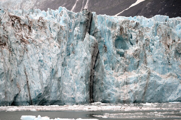 Fissures in the blue ice of the Surprise Glacier in Prince William Sound near Whittier Alaska with smaller ice floes and harbor seals on the floes