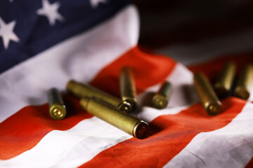 Many bullets cartridges and medals on United States flag. Concept of war glory victory. Gun...